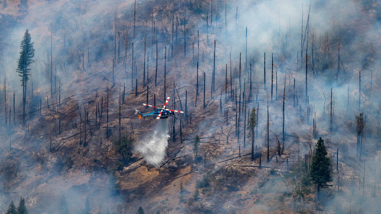 USA, Butte Meadows: Ein Hubschrauber wirft Wasser zum Löschen auf das Park Fire in der Nähe von Butte Meadows, Kalifornien. 