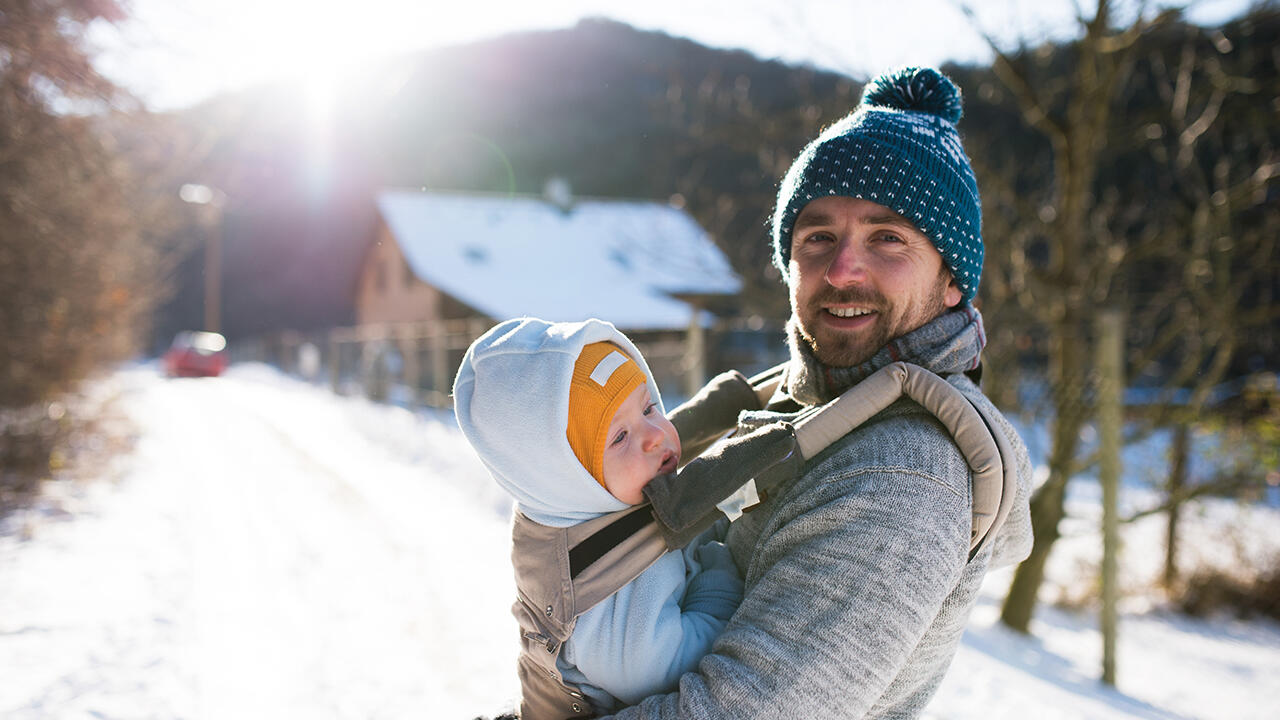 Das Tragen in der Babytrage spendet Kindern Wärme und Geborgenheit. 